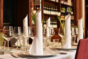 バウツェンにあるMOMENTS Boutique Hotelのワイングラスと白ナプキンをセットしたテーブル
