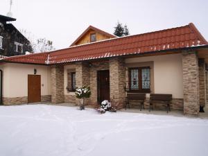 a small building with benches in the snow at Apartmanovy dom Cottage in Liptovský Ján