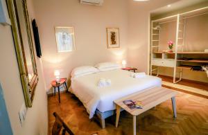 a bedroom with a white bed and a table at Acacia Firenze Apartments Artemisia-Angelica in Florence