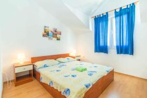 Schlafzimmer mit einem großen Bett und blauen Vorhängen in der Unterkunft Apartmani Jerkin Vodice in Vodice