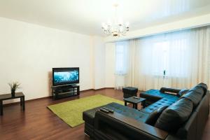 uma sala de estar com um sofá e uma televisão de ecrã plano em Family Apartment em Kazan