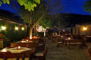 Hotel Alter Posthof في سباي: مطعم خارجي بطاولات وكراسي في الليل