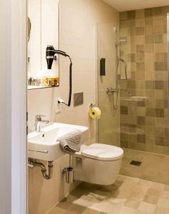 a bathroom with a toilet and a sink and a shower at Gasthaus Zur Noll in Jena