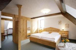 a bedroom with a large wooden bed in a room at Hotel Alter Posthof in Spay