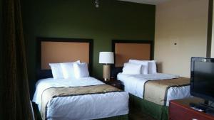 a hotel room with two beds and a television at Extended Stay America Suites - Phoenix - Midtown in Phoenix