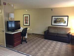 a room with a couch and a desk with a television at Extended Stay America Suites - Phoenix - Midtown in Phoenix