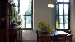 a dining room with a table and chairs and windows at La Limonaia in Camaiore