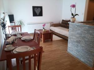a living room with a table and a fireplace at Guest House Domig in Otočac