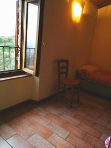 サン・バロントにあるCasa Vacanze "Sereno"のベッド1台、椅子、窓が備わる客室です。