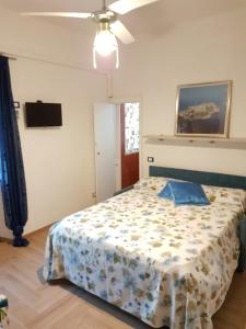 een slaapkamer met een bed met een bloemendeken bij Casa Vittoria in Gaeta