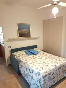 een slaapkamer met een bed en een schilderij aan de muur bij Casa Vittoria in Gaeta