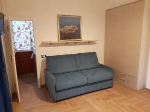 een woonkamer met een blauwe bank voor een deur bij Casa Vittoria in Gaeta