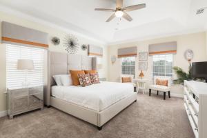 um quarto com uma cama branca e uma ventoinha de tecto em Desert Villa 760-764 em Kissimmee