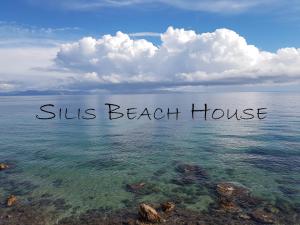 a view of the ocean with the words sliths beach house at Silis Houses on the beach in Artemida