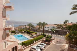 a view of a parking lot with cars and a pool at Apartment in Amdar Residence in Eilat