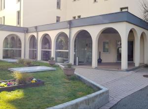 a building with arches and a courtyard with plants at la verte vallée 2 in Munster