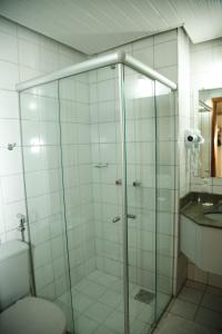 a bathroom with a shower with a toilet and a sink at Villalba Hotel in Uberlândia