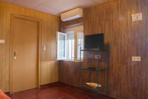 Cette chambre dispose d'une télévision sur un mur en bois. dans l'établissement Vivienda Rural Alba, à Los Albaricoques