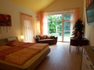 ein Schlafzimmer mit einem Bett, einem Sofa und einem Fenster in der Unterkunft Badische Landoase in Kehl am Rhein