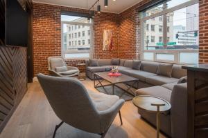 a living room with a couch and chairs and a brick wall at The Mark Spencer Hotel in Portland