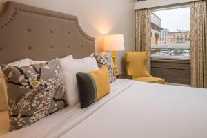 um quarto com uma cama com almofadas e uma janela em The Mark Spencer Hotel em Portland
