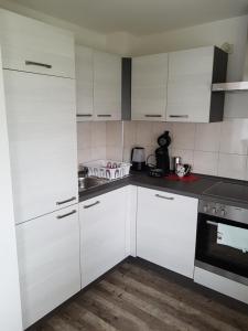 a white kitchen with white cabinets and appliances at Ferienwohnung Zoja in Rust