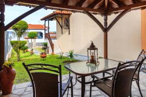 Un patio con mesa y sillas y un jardín. en House Maria, en Agios Nikolaos