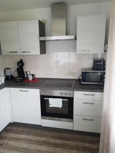 a kitchen with white cabinets and a stove top oven at Ferienwohnung Zoja in Rust