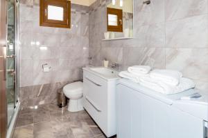 Un baño con lavabo, inodoro y espejo. en House Maria, en Agios Nikolaos 38 fotos más