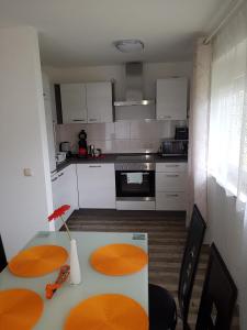 a kitchen with white cabinets and a table and chairs at Ferienwohnung Zoja in Rust