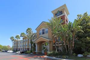 a hotel with palm trees in front of a parking lot at Extended Stay America Suites - Tampa - Airport - N Westshore Blvd in Tampa