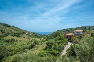 una casa en una colina con un camino de tierra en Il Melograno, en Pollica