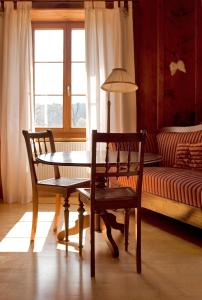 a room with a table and two chairs and a couch at Hôtel de la Chaux-d'Abel in La Ferrière