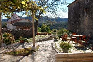 um jardim com uma mesa e cadeiras e um edifício em Pliskovica Youth Hostel em Pliskovica