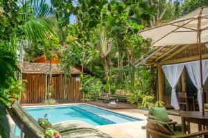 a swimming pool in a garden with a table and chairs at Jardim de Trancoso Pousada in Trancoso