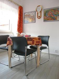 チェスキー・クルムロフにあるApartmán Marieのダイニングルームテーブル(椅子付)、壁掛け時計