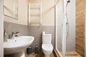 a bathroom with a toilet and a sink and a shower at Boutique Apartments Oradea in Oradea