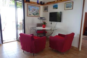 a living room with a table and chairs and a tv at Apartmani Surjan in Vela Luka