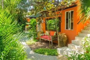 ein orangenes Haus mit einer roten Couch im Garten in der Unterkunft Jardim de Trancoso Pousada in Trancoso