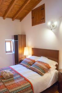 a bedroom with a large bed with a wooden headboard at Casa De Campo De Oliveiras in Penela +78 photos