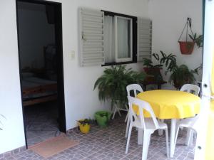 una mesa amarilla y sillas en una habitación con plantas en La Nona en Villa Cura Brochero