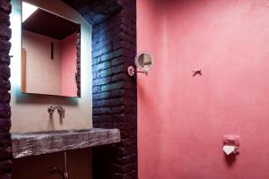 a bathroom with a sink and a red wall at himmel und himmel in Munich