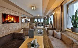 sala de estar con sofás y chimenea en Hotel Silvretta, en Serfaus