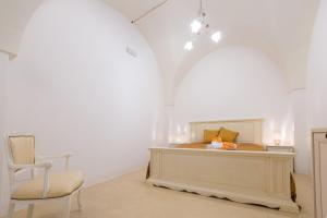 a bedroom with a bed and a chair in a room at Le Volte in Sannicola