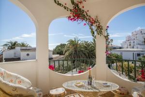 a balcony with a table and chairs and two windows at Casa Tulipa in Luz