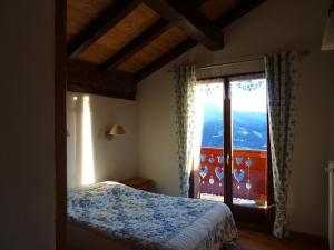 a bedroom with a bed and a large window at Chalet Le Tredard in Feissons-sur-Salins