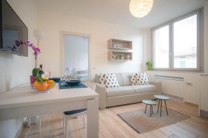 a kitchen and living room with a couch and a table at Comonfive Apartments in Como