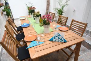 een houten tafel met borden en bloemen erop bij The Grape House in Akko