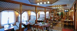 a restaurant with wooden tables and chairs and windows at Penzión Centrál in Oščadnica