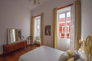 um quarto com uma cama, um espelho e uma janela em Aminta Home em Las Palmas de Gran Canaria